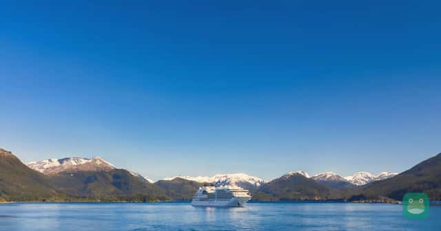 A Seabourn ship in a mountain-ringed fjord